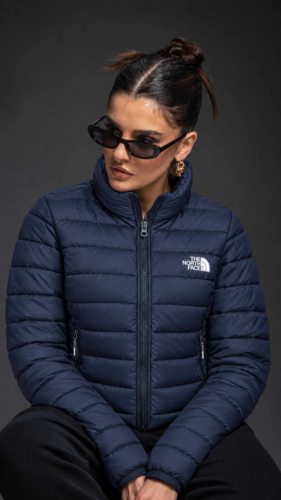 Navy quilted jacket — seated side-facing pose