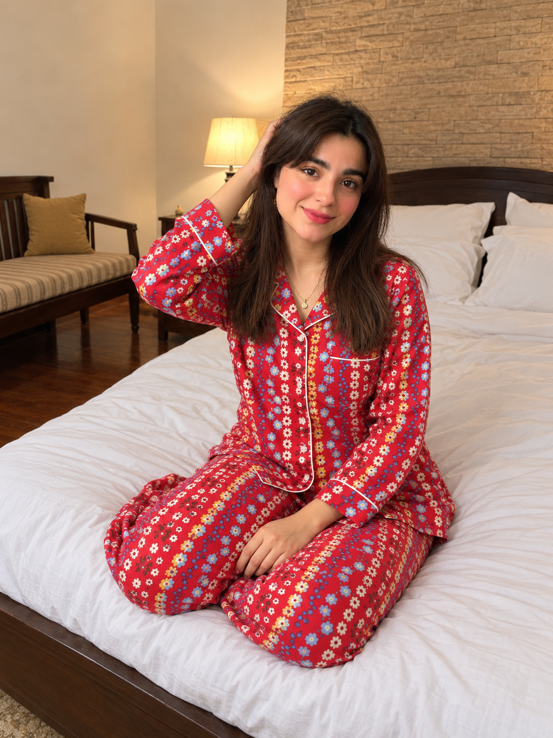 Cherry Bloom red floral linen night suit, seated on the bed with relaxed open hair.